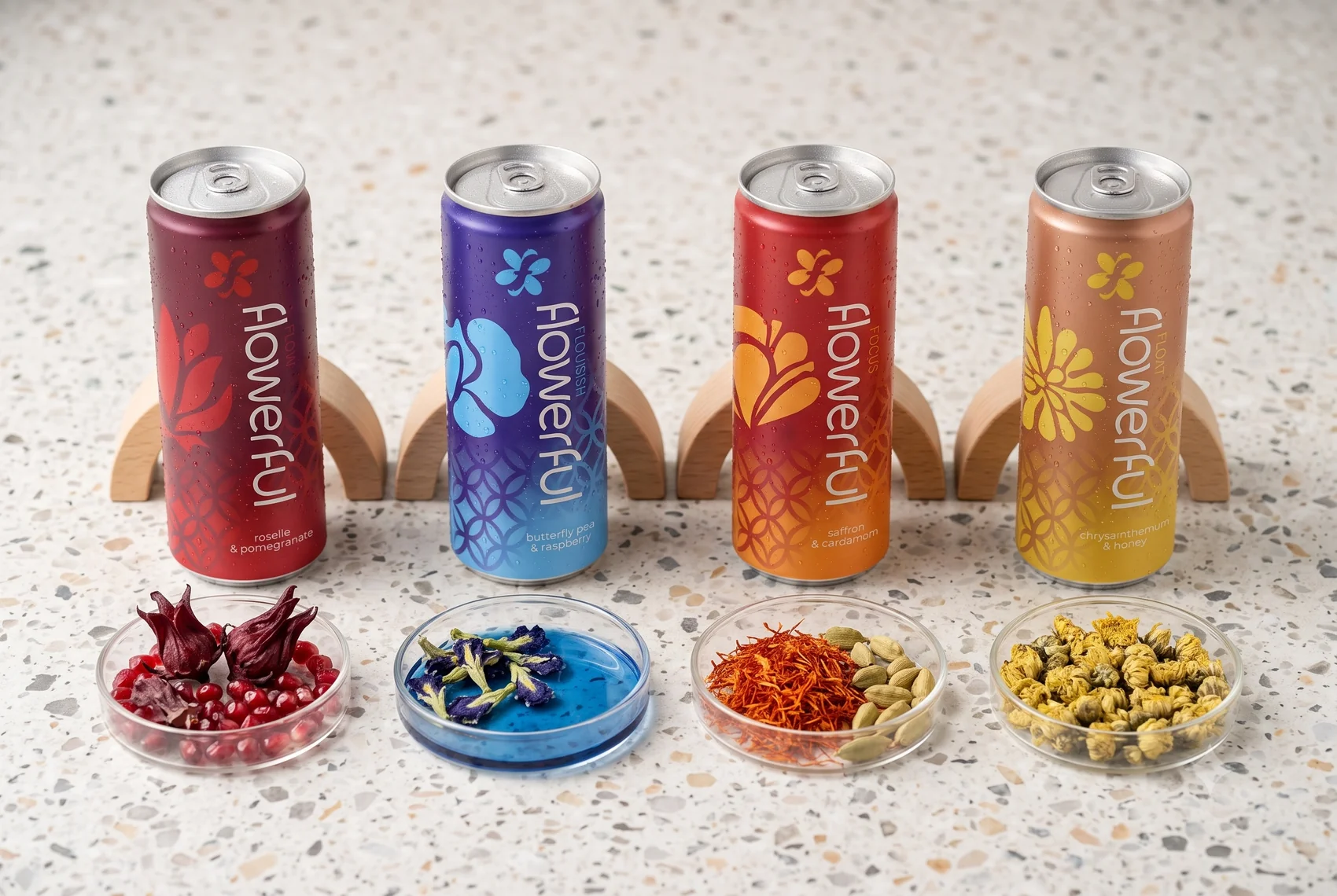 The four hero botanicals behind flowerful, laid out beside each can: roselle, butterfly pea, saffron and chrysanthemum